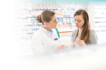 A woman asking a pharmacist about Fleurstat BV treatment gel